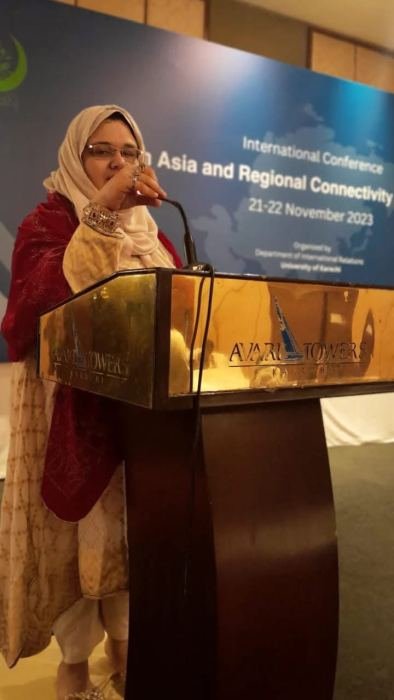 A speaker at a lectern in front of a backdrop for an international conference on Asia and regional connectivity