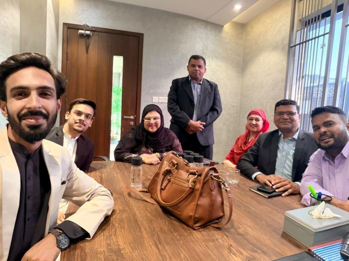 A group seated around a meeting table smiling towards the camera at the end of a planning session